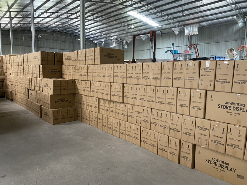 Organized warehouse facility with packaged display racks ready for shipment
